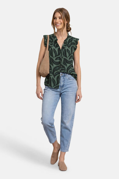 Green sleeveless blouse with leaf pattern and ruffled shoulders by STREET ONE, worn with light blue jeans and tan suede shoes in a full-body lifestyle view.