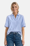 Light blue short-sleeve blouse with pointed collar and rolled cuffs, worn with dark denim jeans, front view
