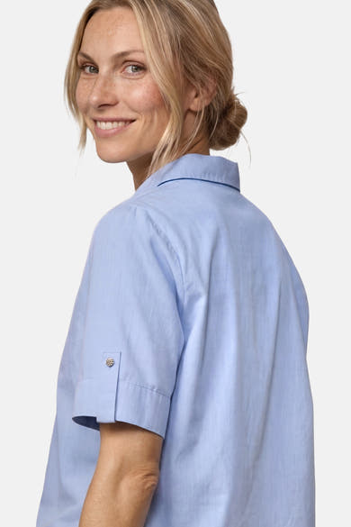 Light blue short-sleeve blouse with buttoned cuffs and collar, side view on model