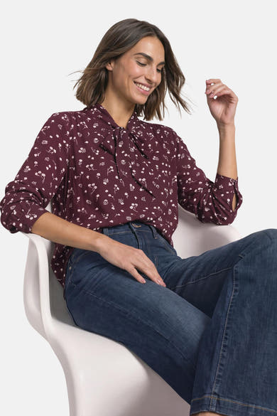 Chemisier à manches longues rouge à motif floral blanc, avec col à nouer, porté par une femme — STREET ONE