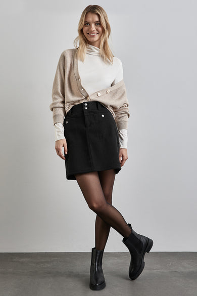 Jupe courte noire de STREET ONE, portée avec un cardigan beige et des bottines noires.
