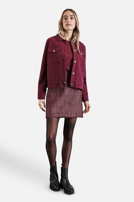 Jupe courte bordeaux STREET ONE avec motif à carreaux, portée avec une veste bordeaux, des collants noirs et des bottines noires.