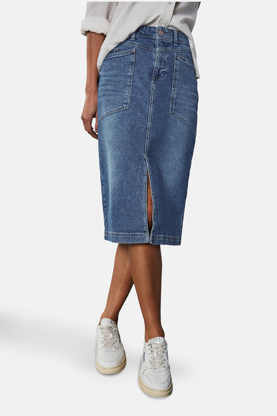 Jupe 3/4 en denim bleu moyen de STREET ONE, fendue sur le devant et portée avec des baskets blanches.
