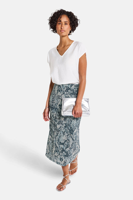 3/4 meerkleurige rok van Street One met slangenprint en zilveren clutch in de hand.