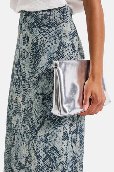 3/4 meerkleurige rok van Street One, met slangenprint, gedragen met een zilveren clutch.