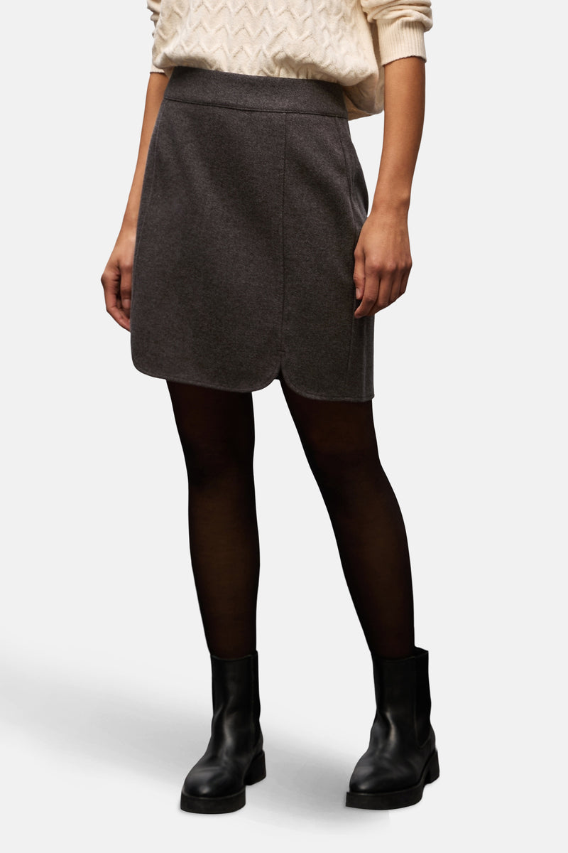 Korte bruine rok van STREET ONE, klassieke stijl met afgeronde zoom, gedragen met een zwarte panty en leren enkellaarsjes.