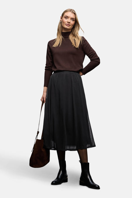 Jupe longue noire de STREET ONE, avec une doublure et portée avec un pull marron et des bottines noires.