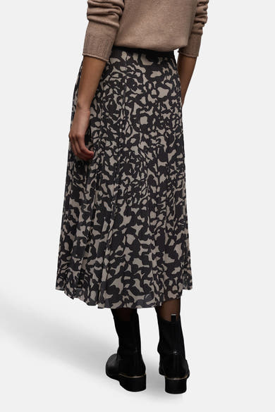 Jupe mi-longue marron de Street One, motif abstrait noir et beige, portée avec des bottines noires.
