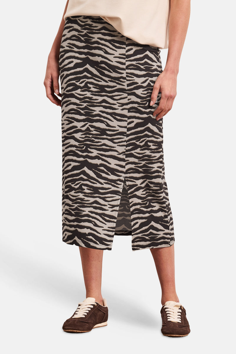 Jupe mi-longue imprimé zèbre noir et beige de STREET ONE, avec une fente avant, portée avec un haut clair et des baskets.