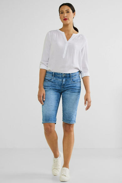 Bermuda court bleu de Street One, porté avec une chemise blanche à manches trois-quarts et des chaussures blanches.