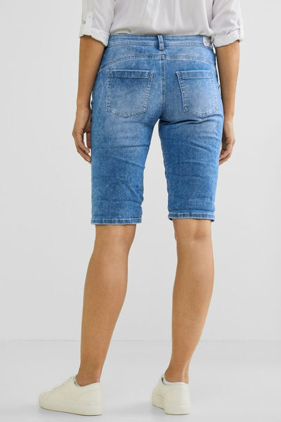 Bermuda courte bleu de STREET ONE, avec poches arrière et chaussures de sport blanches.