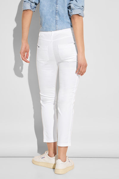 Pantalon coloré blanc de Street One, avec poches arrière et porté avec une chemise en jean.