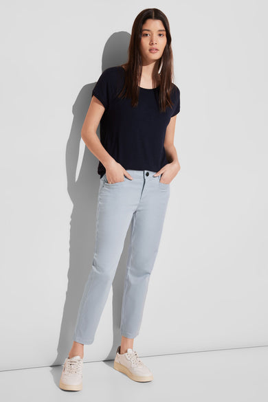 Pantalon coloré bleu de STREET ONE, porté avec un T-shirt marine et des baskets beiges.