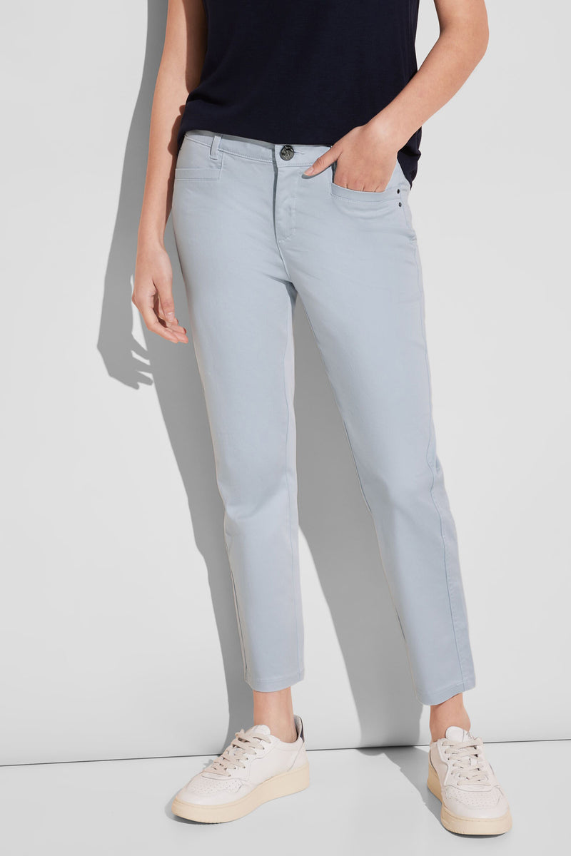 Pantalon coloré bleu de STREET ONE, porté avec un t-shirt bleu marine et des baskets blanches.
