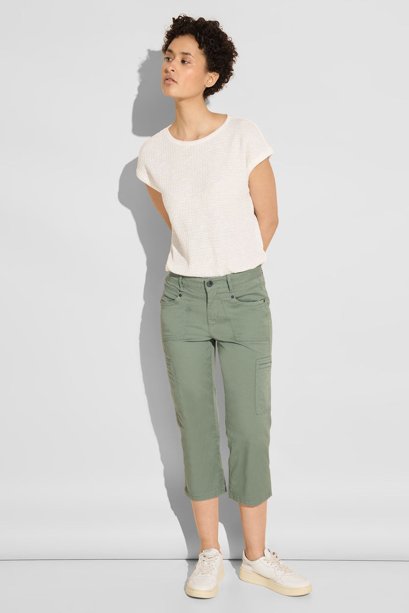 Pantalon cargo vert de Street One, porté avec un t-shirt texturé couleur crème et des baskets blanches à semelle compensée.