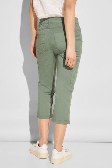 Pantalon cargo vert par Street One, longueur 3/4, avec poches latérales et portées avec des baskets crème.