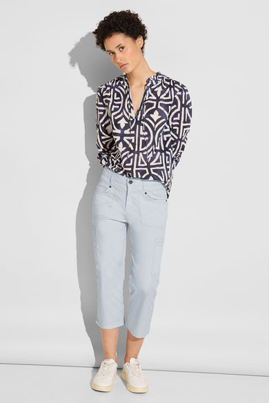Pantalon cargo bleu de Street One, coupe décontractée, porté avec un chemisier à motifs et des chaussures de sport.