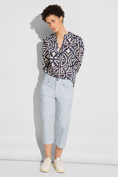 Pantalon cargo bleu de Street One, coupe décontractée, porté avec un chemisier à motifs et des chaussures de sport.