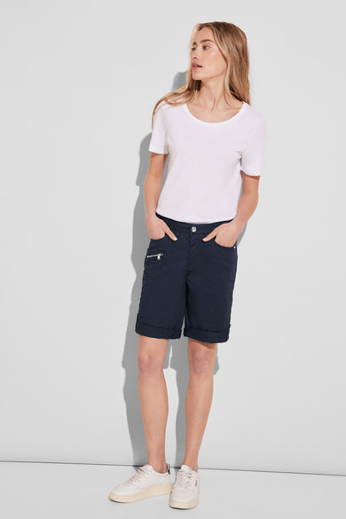 Bermuda bleu de STREET ONE, avec poches zippées et ourlets roulés, porté avec un t-shirt blanc et des chaussures de sport.