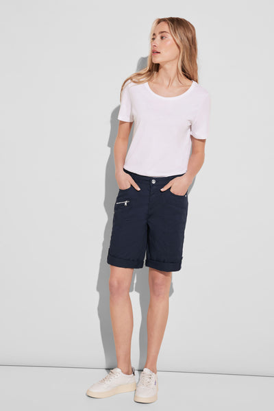 Bermuda bleu de STREET ONE, avec poches zippées et ourlets roulés, porté avec un t-shirt blanc et des chaussures de sport.