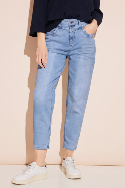 Jean mom en denim bleu clair de Street One, porté avec un chemisier bleu marine et des baskets blanches.