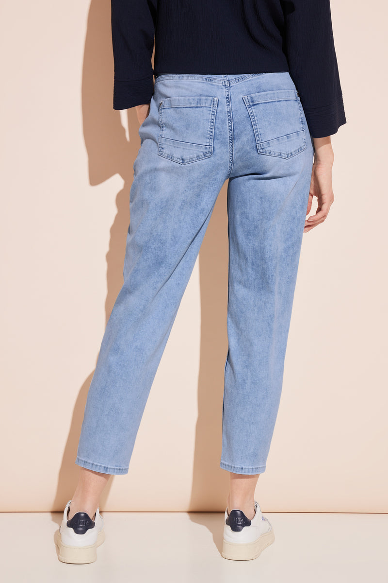 Jeans mom en denim bleu clair de Street One, avec poches arrières et chaussures blanches.
