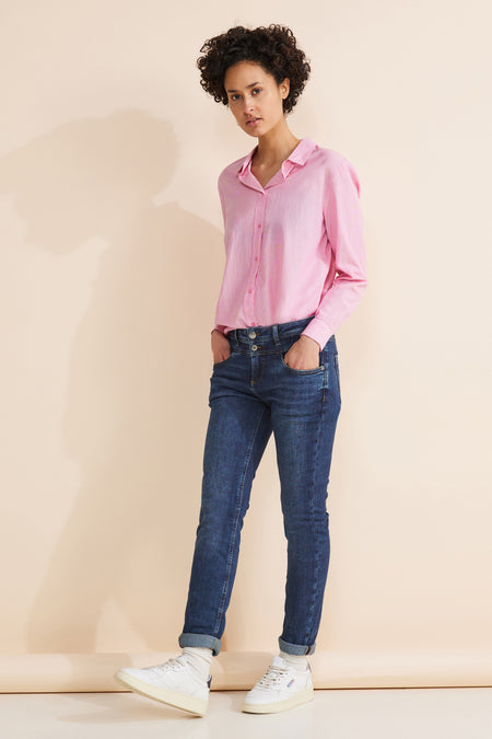 Middelblauwe diverse spijkerbroek voor dames van STREET ONE, gedragen met een gestreept roze overhemd en witte sneakers.