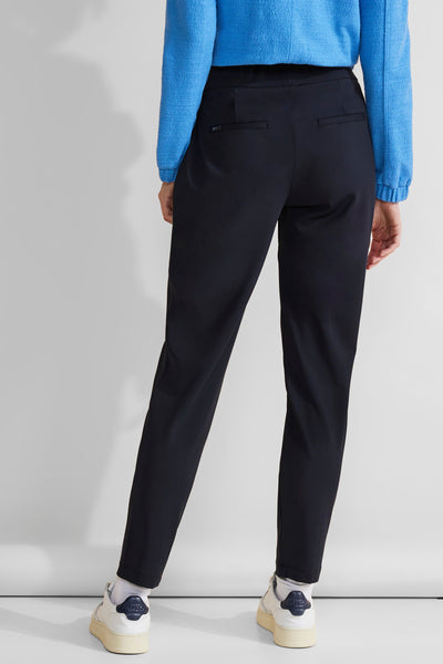 Pantalon cargo bleu de STREET ONE, coupe fuselée, avec poches arrière passepoilées et porté avec un pull bleu.
