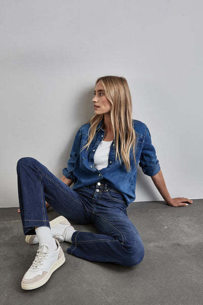 Jean bootcut bleu de STREET ONE porté avec une chemise en jean et des baskets blanches, en situation de style.