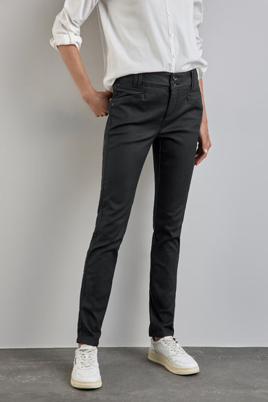 Pantalon noir de STREET ONE porté avec une chemise blanche et des baskets blanches.
