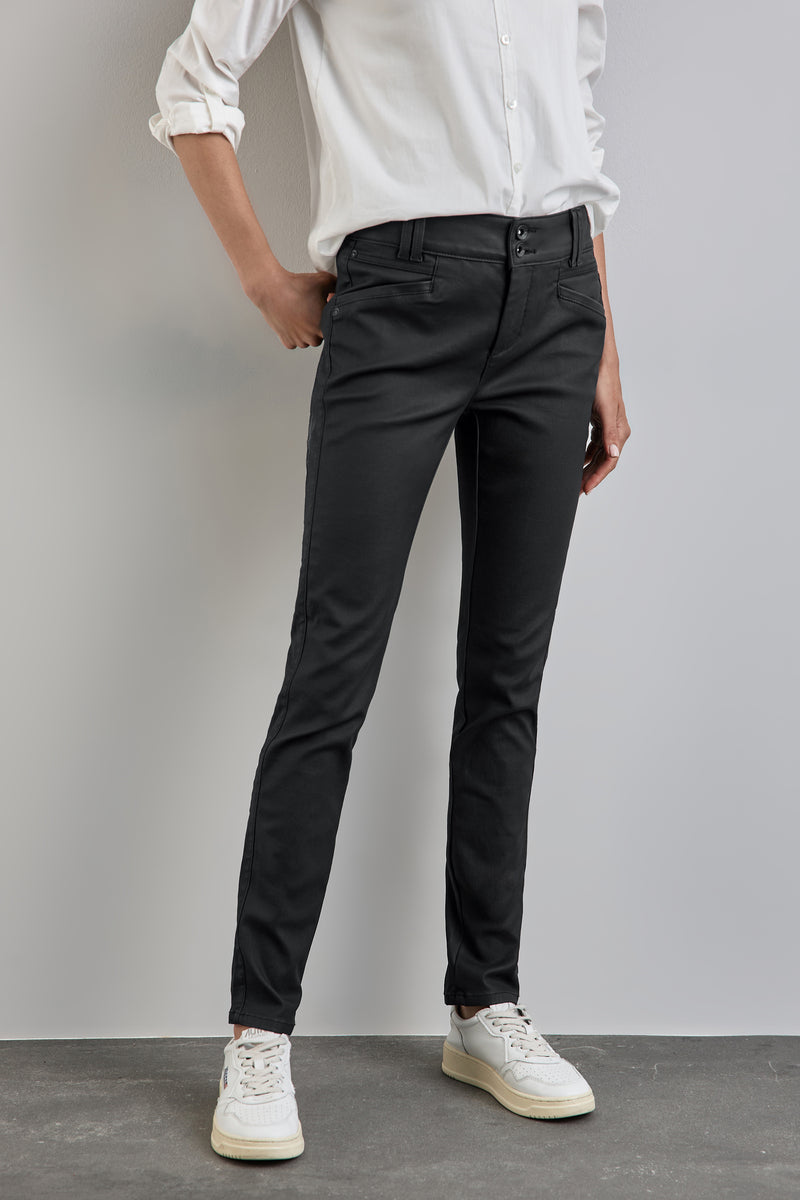 Pantalon noir de STREET ONE porté avec une chemise blanche et des baskets blanches.
