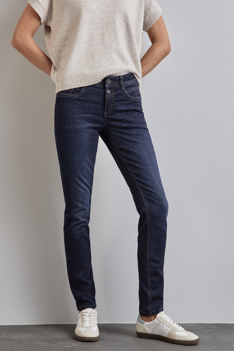 Skinny jeans in donkerblauw denim van STREET ONE, gedragen met een gebreide trui en witte sneakers.