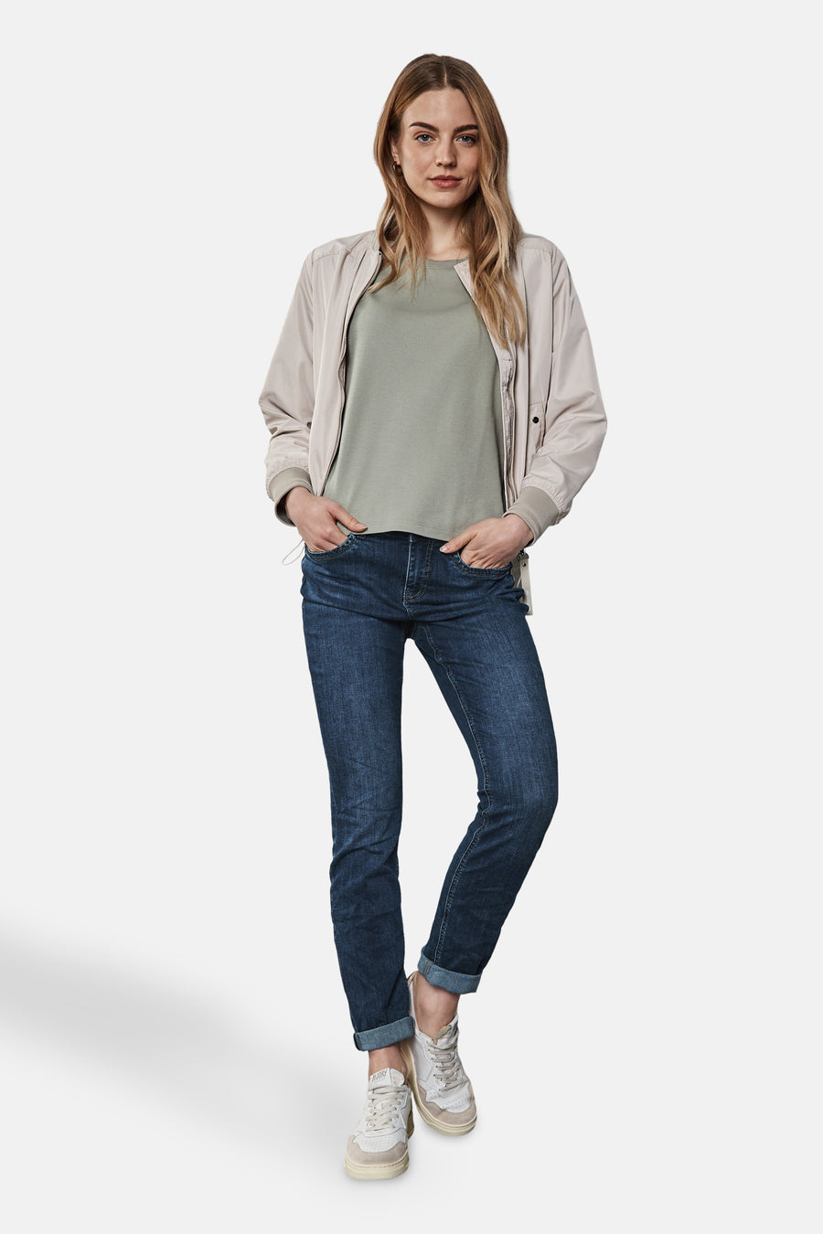 Jean slim en denim bleu foncé de Street One porté avec un blouson beige et des baskets blanches.