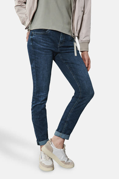 Jean slim en denim bleu foncé de STREET ONE, porté avec des revers et un blouson beige.