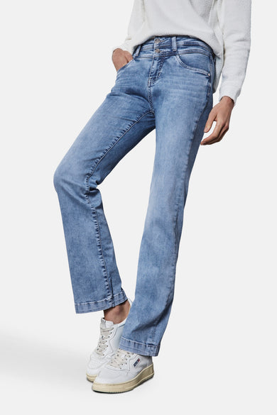 Jean bootcut in lichtblauw denim van Street One, gedragen met een witte textuurgebreide trui en witte sneakers.