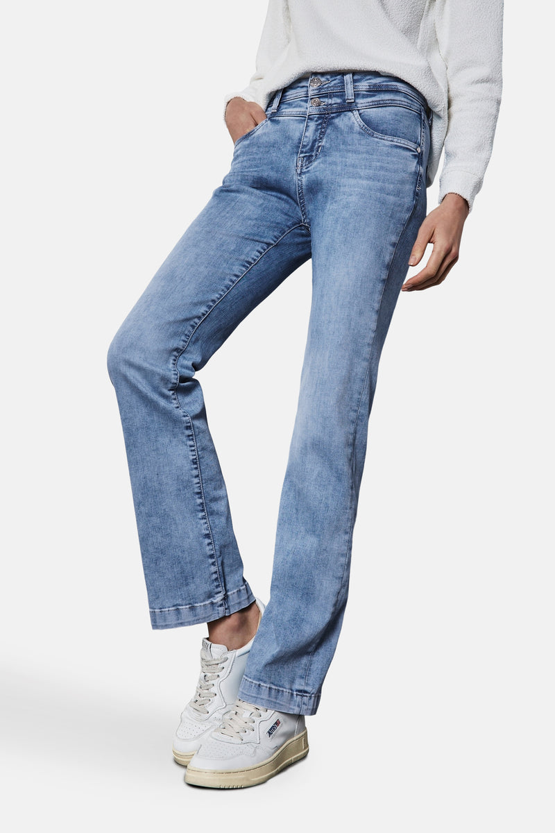 Jean bootcut in lichtblauw denim van Street One, gedragen met een witte textuurgebreide trui en witte sneakers.
