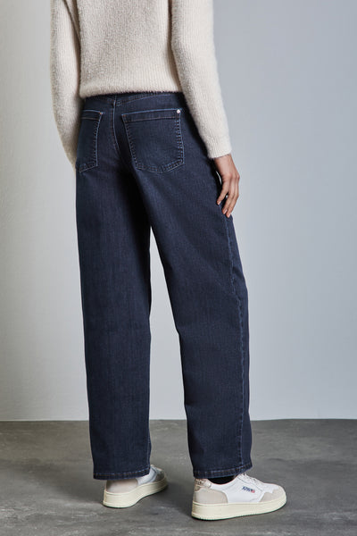 Wijde spijkerbroek in donkerblauw denim van STREET ONE, gedragen met een crèmekleurige trui en witte sneakers.