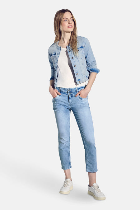 Slim jeans in lichtblauw denim van STREET ONE, gedragen met een spijkerjasje en witte sneakers.