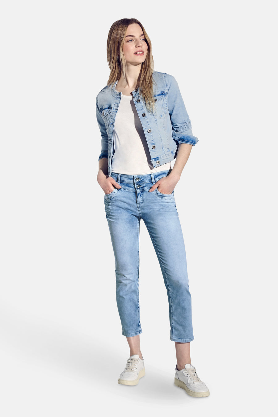 Jean slim en denim bleu clair de STREET ONE, porté avec une veste en jean et des baskets blanches.