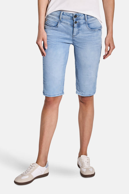 Bermuda en denim bleu clair de Street One, court et décontracté, porté avec des chaussures de sport blanches.
