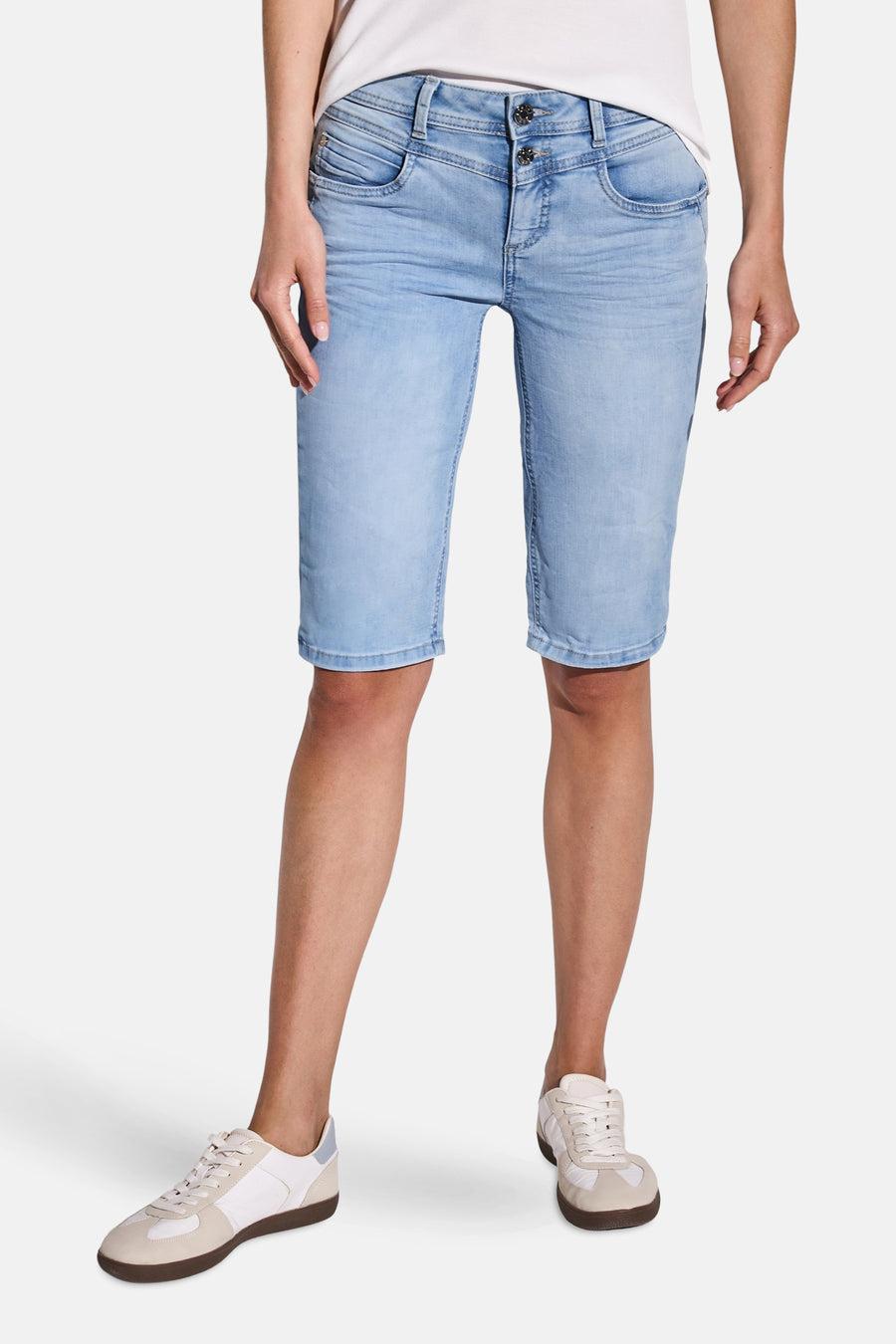 Bermuda en denim bleu clair de Street One, court et décontracté, porté avec des chaussures de sport blanches.
