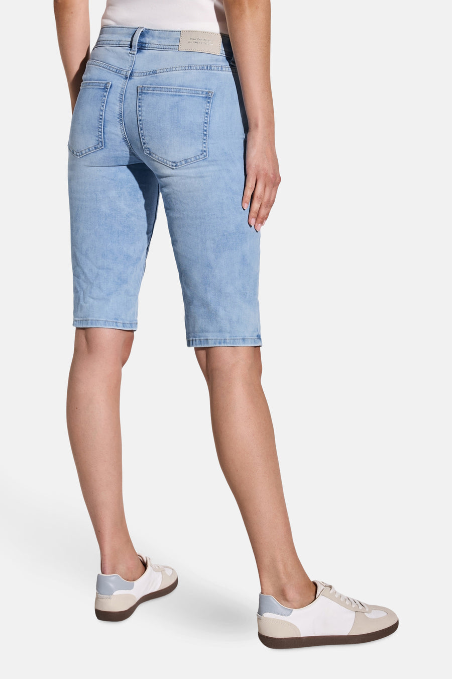Bermuda en denim bleu clair de STREET ONE, vue de dos, porté avec des baskets blanches et beiges.
