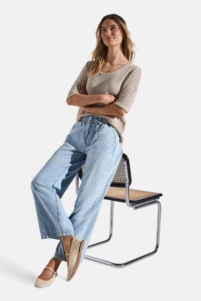 Jean large en denim bleu clair de STREET ONE, porté avec un pull beige et des chaussures plates.