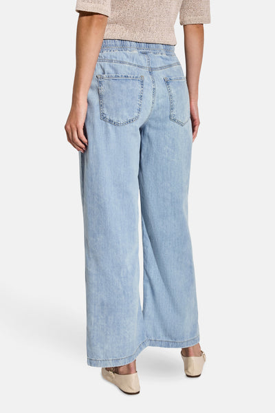 Jean large en denim bleu clair de Street One, coupe ample, avec poches arrière et chaussures beiges.