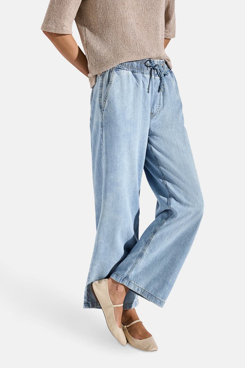 Jean large en denim bleu clair de Street One, porté avec un haut tricoté neutre et des ballerines couleur crème.
