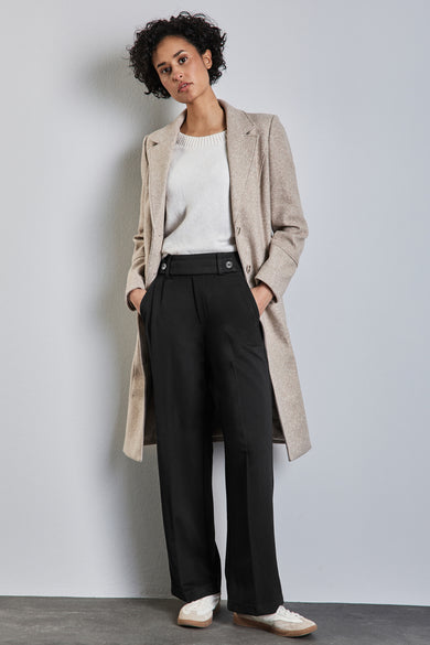 Pantalon de costume noir de chez STREET ONE, porté avec un pull blanc cassé et un manteau beige.

