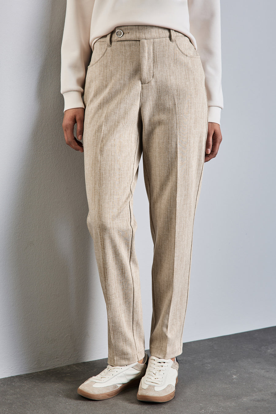 Beige chino van STREET ONE, stoffen broek met zakken en knoop, gedragen met een gebroken witte trui en sneakers.