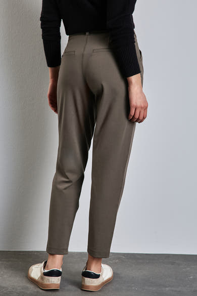 Bruine chino van STREET ONE, losse pasvorm, met een zwarte trui en gebroken witte sneakers.