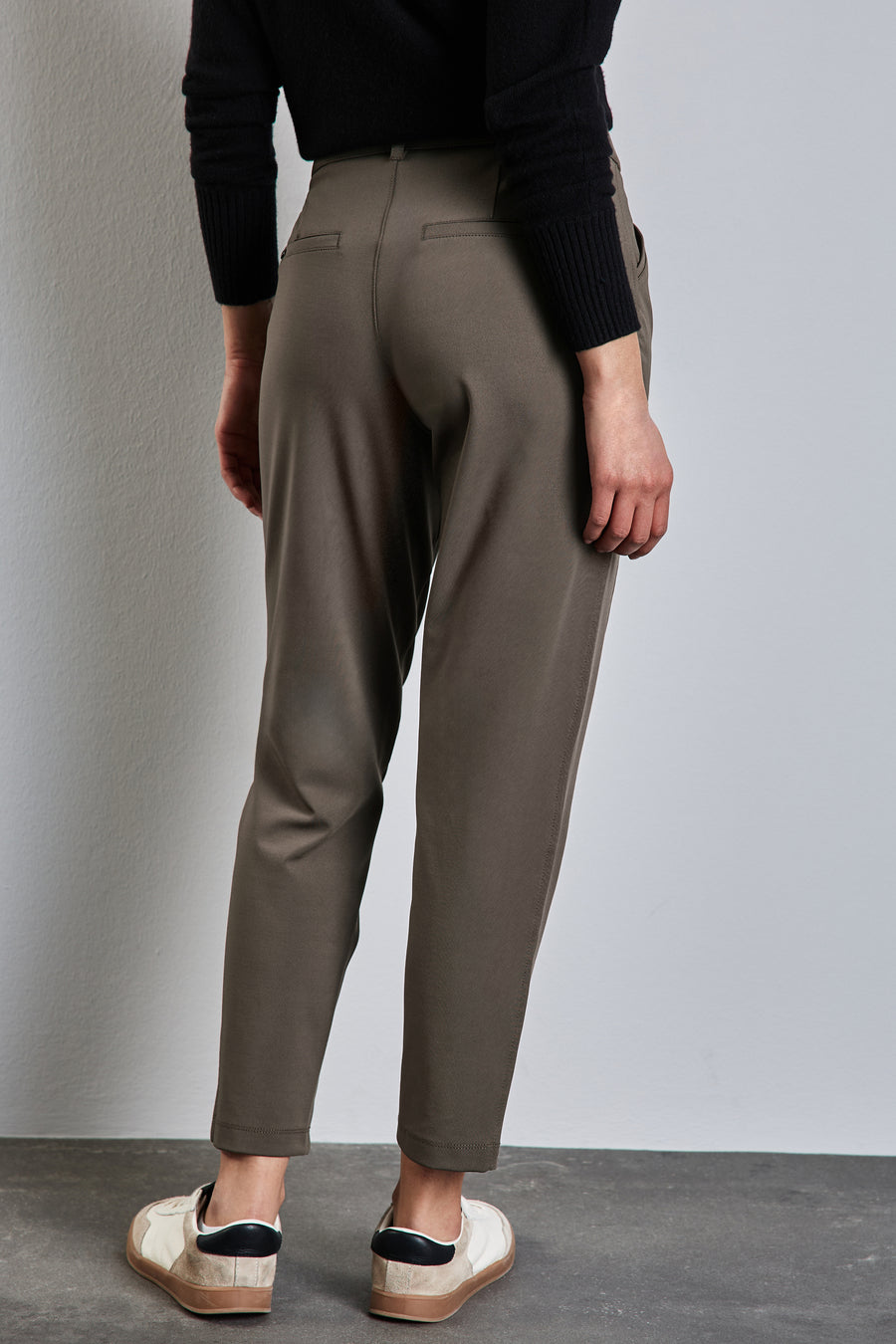 Bruine chino van STREET ONE, losse pasvorm, met een zwarte trui en gebroken witte sneakers.