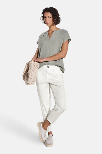 Chino blanc de Street One, porté avec un haut vert texturé et des baskets blanches et beiges.